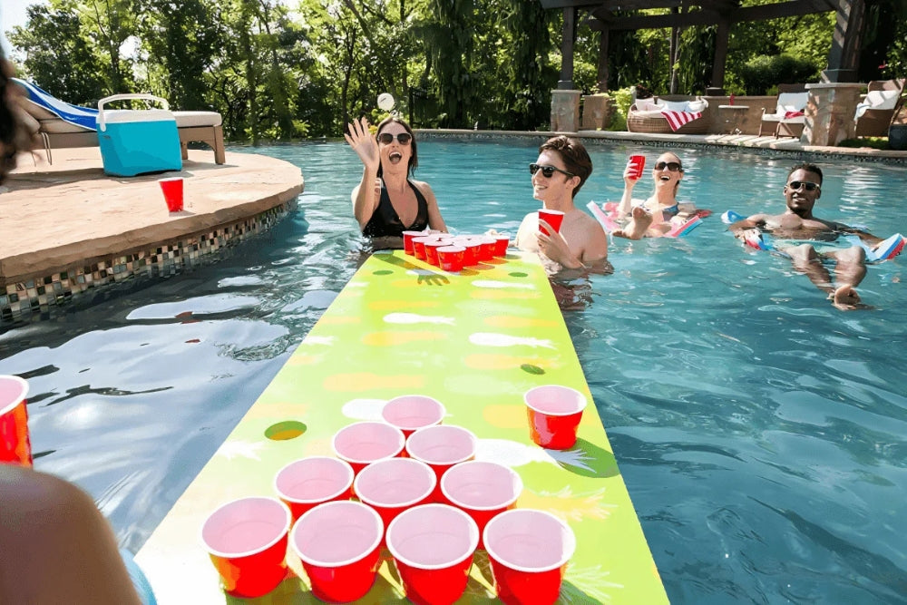 friends playing beer pong on an inflatable table in a swimming pool